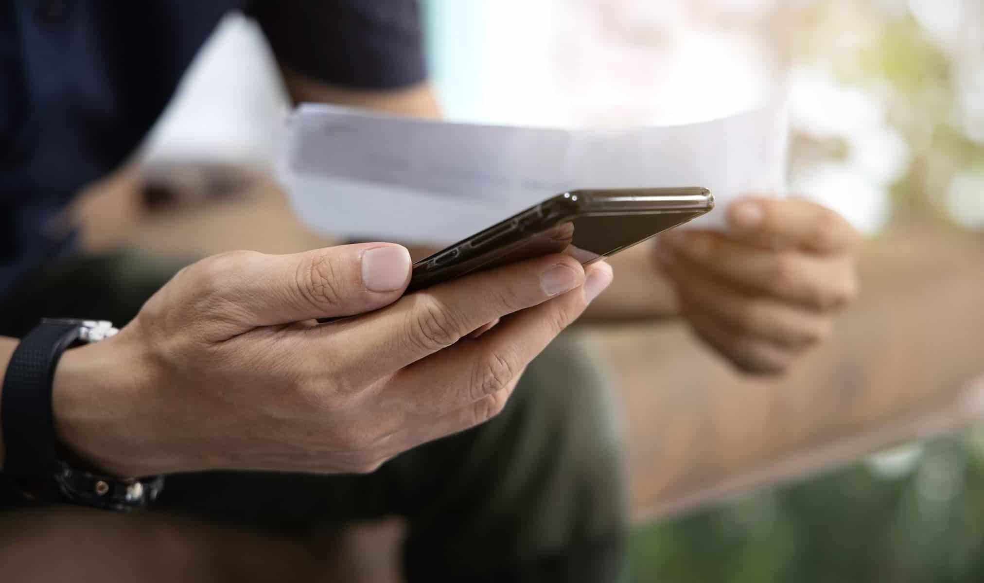 Försäkra utgifter mot oförutsedda händelser 5 Man med mobil och faktura i handen